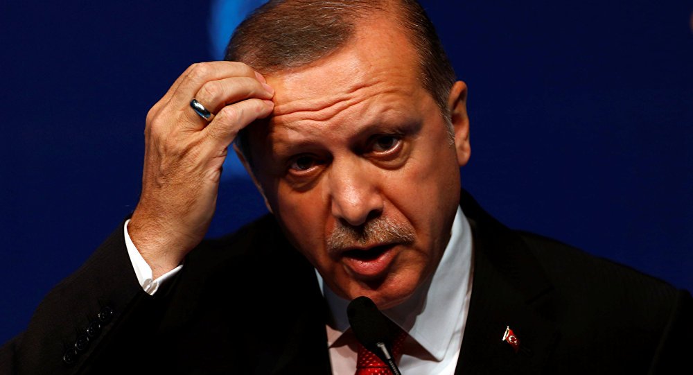 الرئيس التركي رجب طيب أردوغان ويضع يده على رأسه