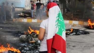 متظاهر في لبنان يرتدي العلم في بيروت