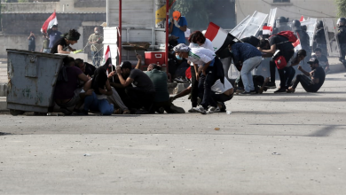 متظاهرون يختبؤون من غاز قوات الأمن خلال مظاهرات العراق