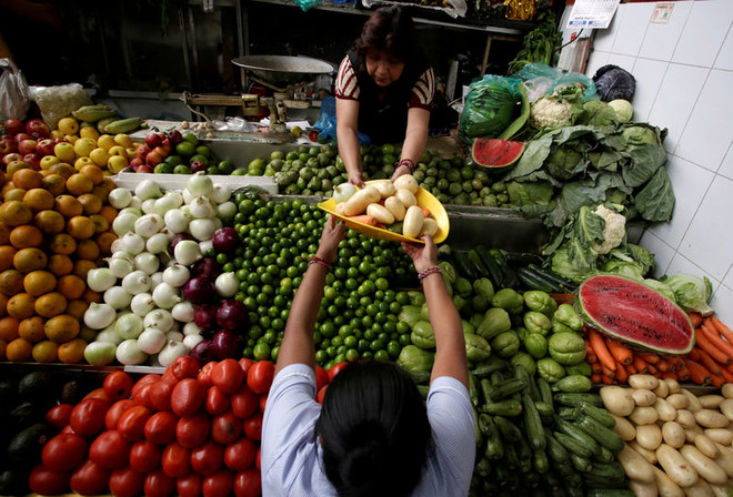 امرأة تشتري خضروات من سوق في المكسيك