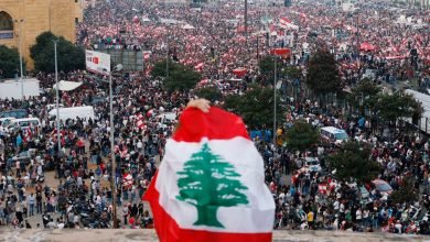 متظاهر يغطي ظهره علم لبنان