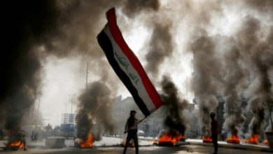 متظاهر عراقي يلوح بالعلم