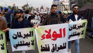 متظاهرون عراقيون يرفعون لافتات للولاء للعراق