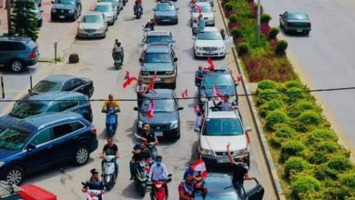 موكب سيارات يرفع أعلام لبنان احتجاجا