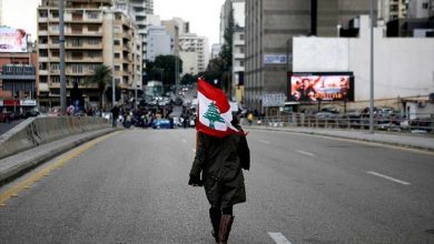 متظاهر لبناني يحمل العلم
