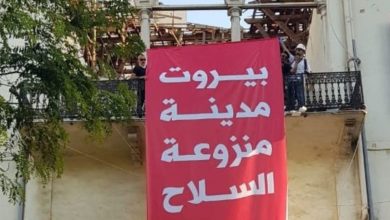 متظاهرون يعلقون لافته لبنان منزوع السلاح